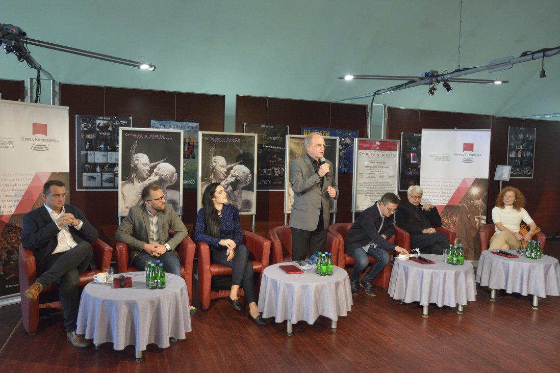 Bogusław Nowak, Dyrektor Opery, stoi, wypowiadając się do mikrofonu. Po obu stronach pozostali uczestnicy siedzą w czerwonych fotelach przy niskich stolikach. W tle plakaty spektaklu.